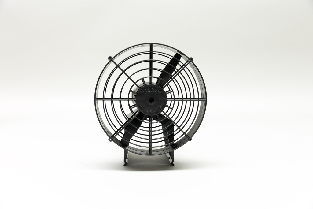 Ein schwarzer Ventilator mit Schutzgitter steht zentral vor einem weißen Hintergrund. Das Gerät ist für den Einsatz in wissenschaftlichen Experimenten konzipiert.
