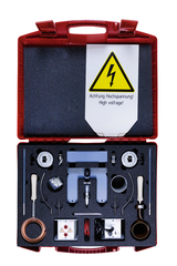 Ein roter Koffer enthält diverse physikalische Experimentiergeräte, darunter Elektroden und Messinstrumente in Schaumstoffaussparungen. Ein gelbes Warnschild weist deutlich auf die Gefahr von Hochspannung hin.