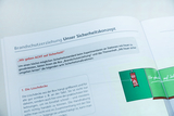 Eine geöffnete Broschüre zum Thema Brandschutzerziehung erläutert ein Sicherheitskonzept für Experimente mit Feuer. Gezeigt werden Textpassagen zu Sicherheitsmaßnahmen sowie ein Bild einer Löschdecke.