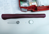 Ein Set für Chemieexperimente umfasst eine rote Materialbox mit Pulverproben und einer Anleitung. Im Vordergrund liegen eine Pinzette, ein Streichholz und ein kleines Glasgefäß auf weißem Untergrund.