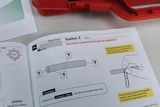 Ein aufgeschlagenes Schulheft zeigt eine Anleitung zu einem Experiment über Magnetismus. Gezeigt wird die Station 3 mit der Fragestellung zur Stärke der magnetischen Kraft sowie einer illustrierten Versuchsanordnung mit einer Büroklammer.