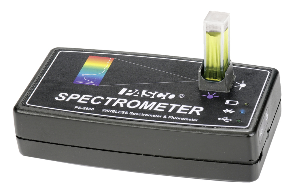 Ein schwarzes PASCO Spektrometer PS-2600 ist auf weißem Hintergrund abgebildet. In einer Halterung steckt eine Küvette mit einer gelbgrünen Flüssigkeit.
