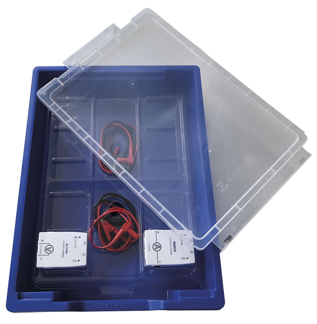 Eine blaue Kunststoffbox enthält zwei weiße Messgeräte der Marke PASCO sowie rote und schwarze Verbindungskabel. Ein transparenter Deckel liegt leicht versetzt auf dem Set.