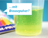 Ein Plastikbecher enthält eine sprudelnde, hellgrüne Flüssigkeit. Eine Sprechblase stellt die Frage: „...mit Brausepulver?“.