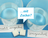 Zwei Gläser mit einer bläulichen Flüssigkeit stehen neben zwei Zuckerwürfeln. Beschriftungen weisen auf Versuche mit und ohne Umrühren hin, ergänzt durch die Frage „...mit Zucker?“.