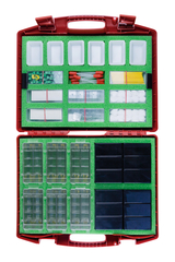 Ein geöffneter roter Koffer enthält verschiedene Sortimente an Experimentierzubehör in Kunststofffächern. Auf grünem Grund sind unter anderem Wattestäbchen, Streichhölzer und zahlreiche kleine elektronische Bauteile systematisch angeordnet.